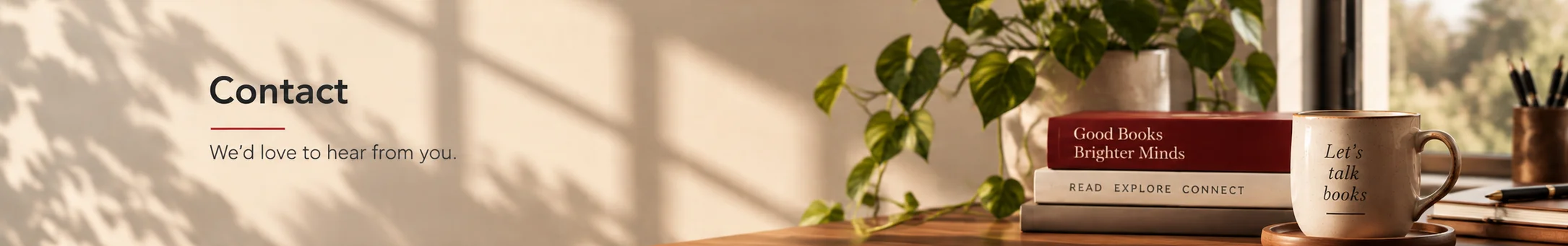 Cozy contact page banner with stacked books, a plant, coffee mug, notebook, and warm natural light