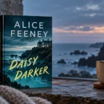 Daisy Darker by Alice Feeney displayed in a moody coastal reading scene with a remote island house, candlelight, coffee, and stormy sea views